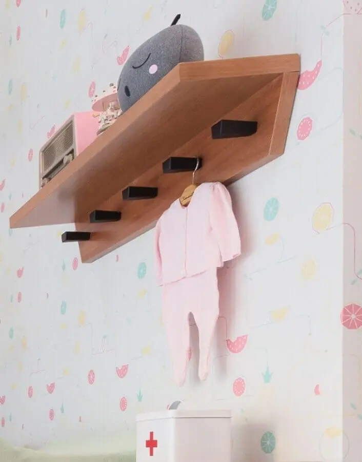 prateleira de madeira para quarto de bebê com ganchos decorado com roupinha de bebê Foto Blog da Giovanna