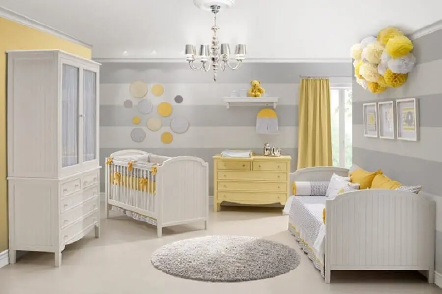 quarto de bebê cinza e amarelo decorado com tapete redondo e papel de parede listrado Foto Construção e Design