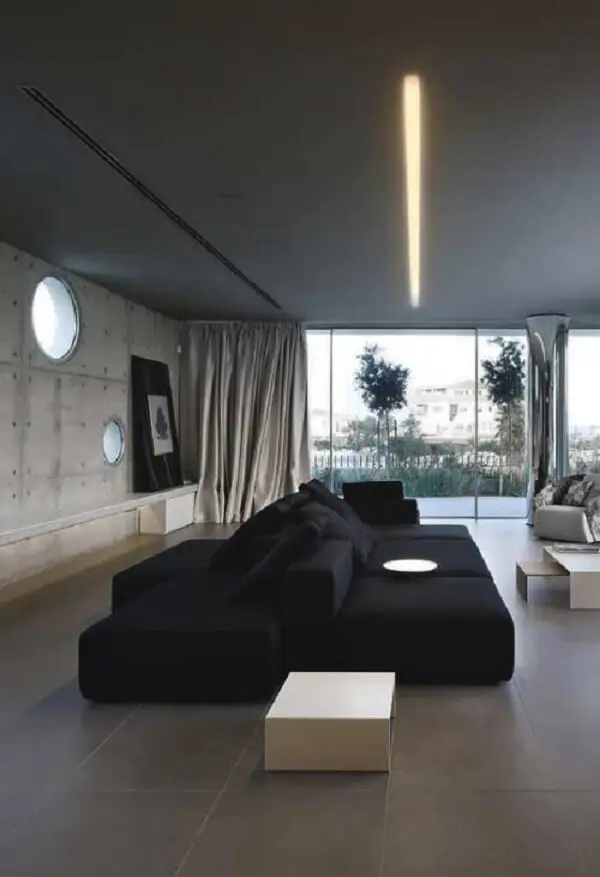 Ambiente integrado com sofá preto interligado com encosto