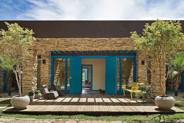 Casa de chácara com fachada de pedras e porta azul
