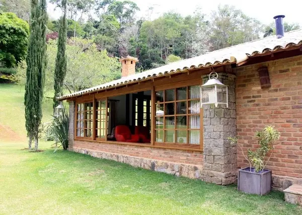 Casa rústica com acabamento externo de pedras e tijolo aparente