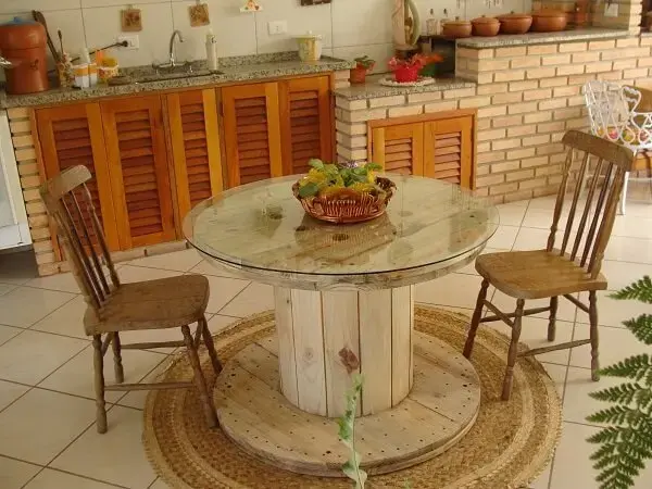 Sala de jantar com mesa de carretel de madeira com vidro