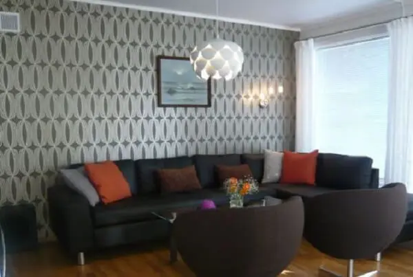 O papel de parede harmonizou bem com o sofá de canto preto