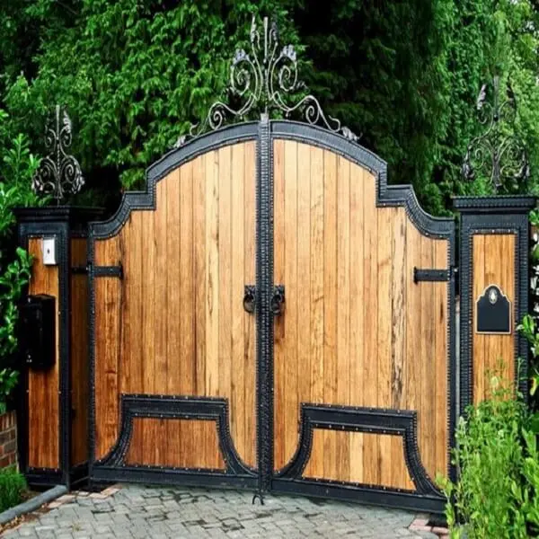 Portão alto em madeira e ferro compõe a entrada de chácara