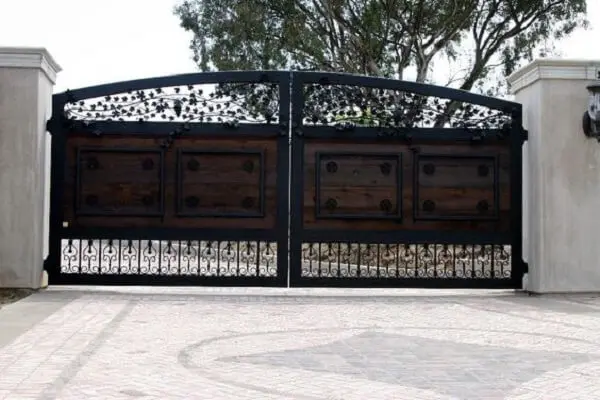 Portão com acabamento ao centro em madeira usado na entrada de chácara