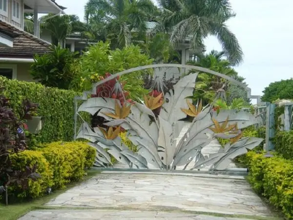 Portão com design de folhas encantam a entrada de chácara