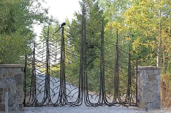 Portão em formato de pinheiro compõem a entrada de chácara