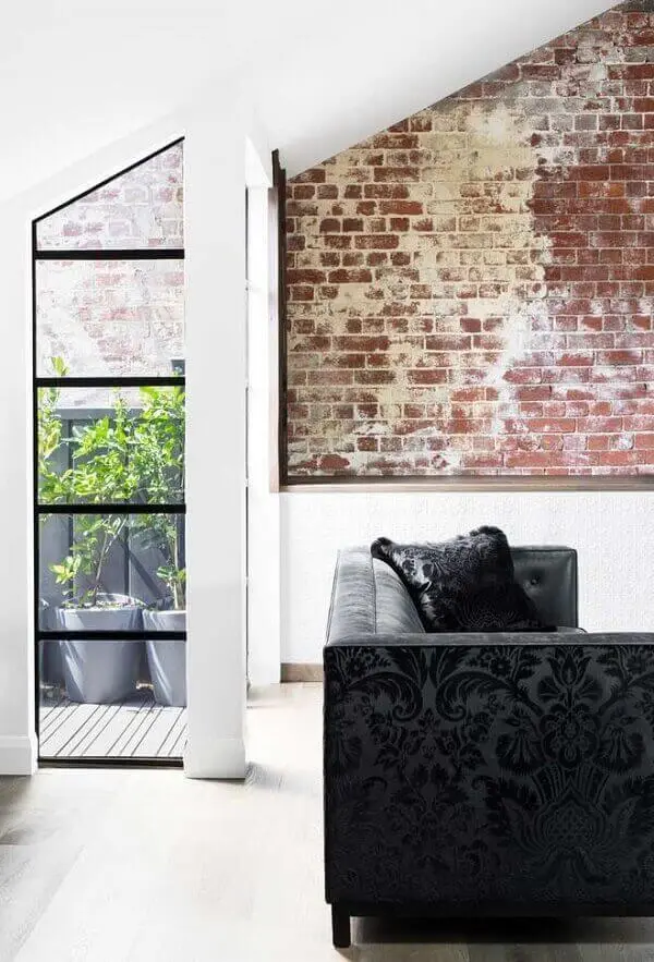 Sofá preto com tecido em textura complementa a decoração do ambiente