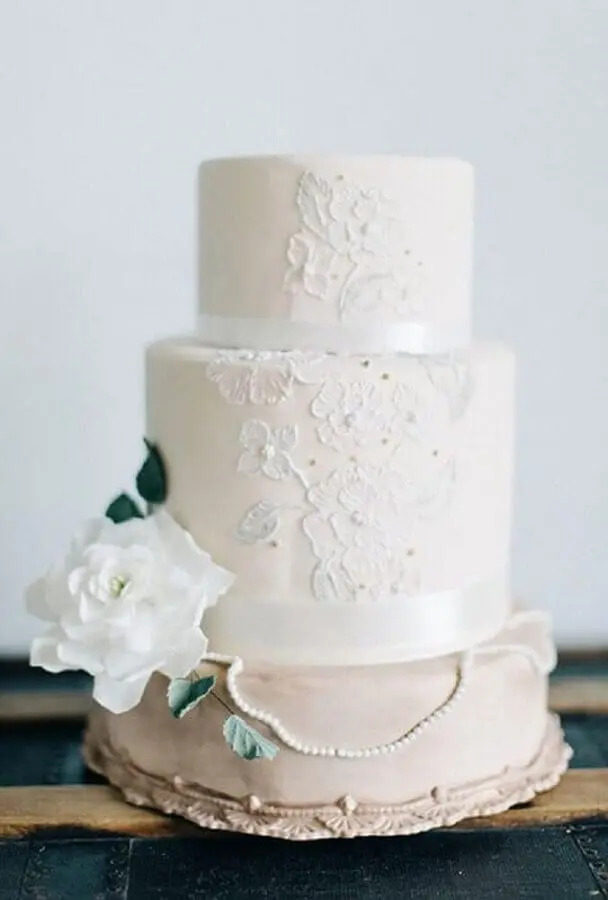 bolo bodas de pérola decorado com renda e flor branca Foto Brides