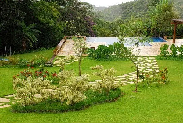 Área externa da casa de chácara com jardim e piscina