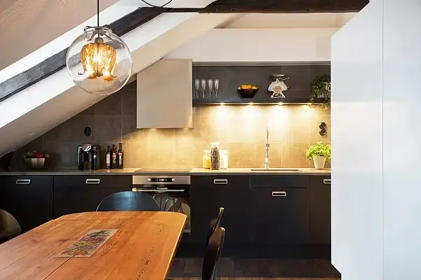 Cozinha compacta com móveis planejados compõem o sótão dessa casa