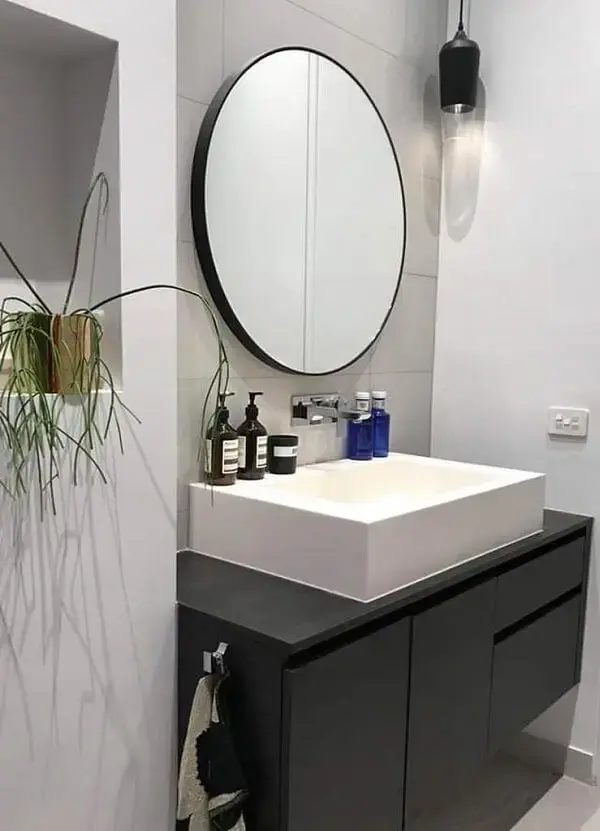 O espelho redondo se conecta com o restante da decoração do banheiro