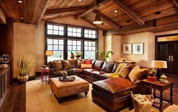 Sótão com sala de estar ao estilo rústico e sofá de couro