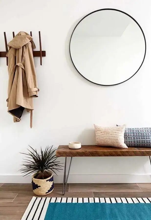 decoração minimalista com espelho redondo grande e banco de madeira Foto Danish Builders