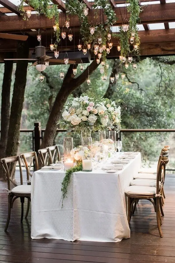 decoração romântica para bodas de casamento com arranjos de flores e velas suspensas Foto MODwedding