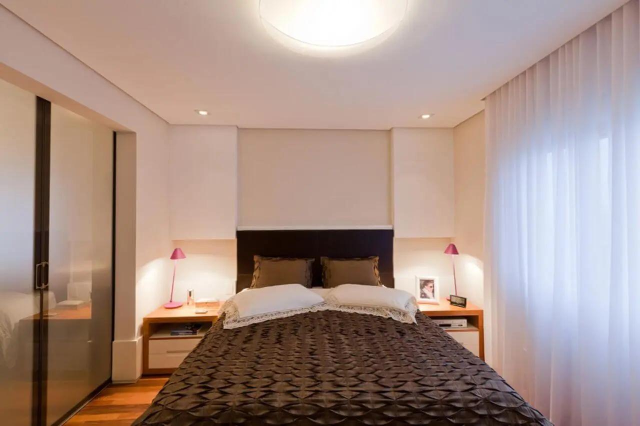 quarto de casal moderno - cama centralizada, com lençois marrons e ao lado de janela com cortina