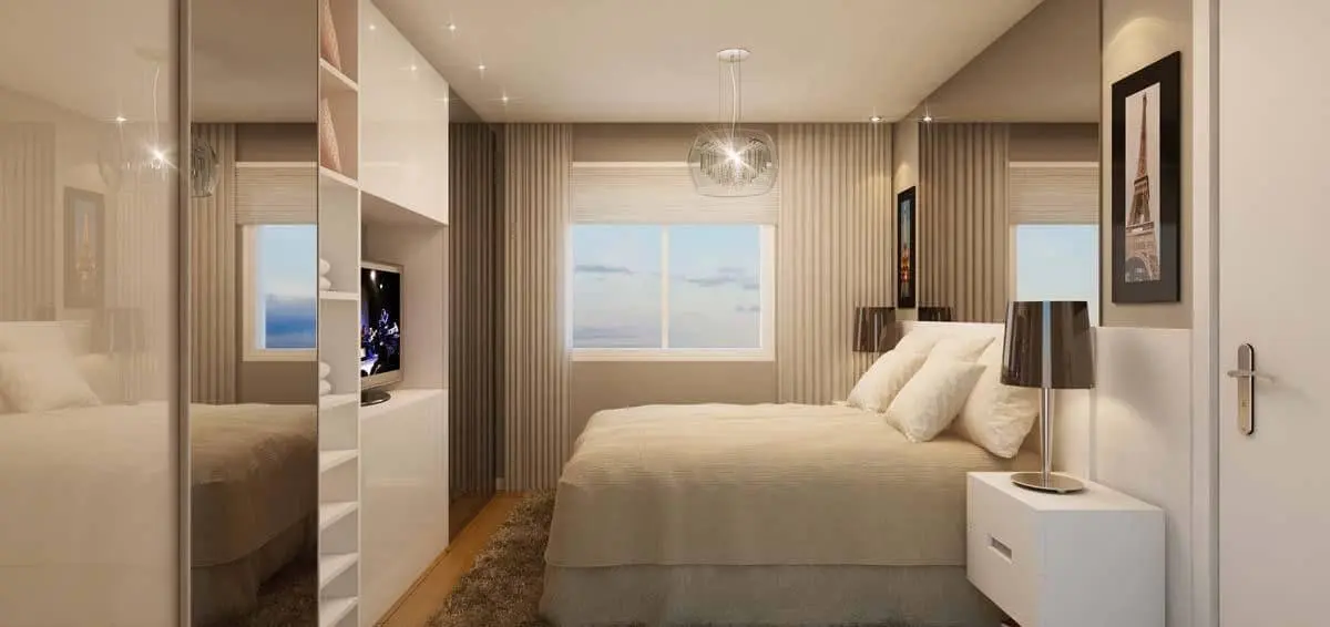 quarto de casal moderno - cama centralizada, em frente à guarda roupa com televisão e ao lado de abajur
