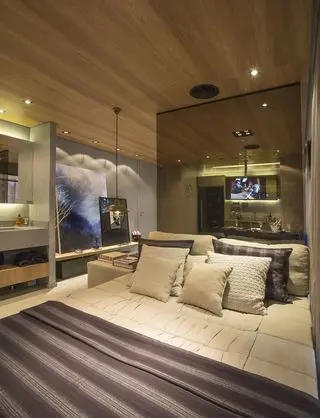 quarto de casal moderno - cama com lençóis listrados e parede de espelho