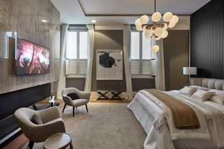 quarto de casal moderno - cama em frente a poltronas creme em tapete cinza