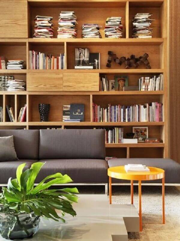 sala decorada com sofá cinza e estante de madeira para livros Foto FRISO – Arquitetura e Interiores