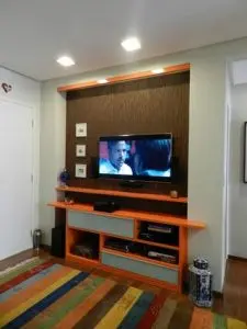 tinta para madeira - quarto com painel de televisão laranja