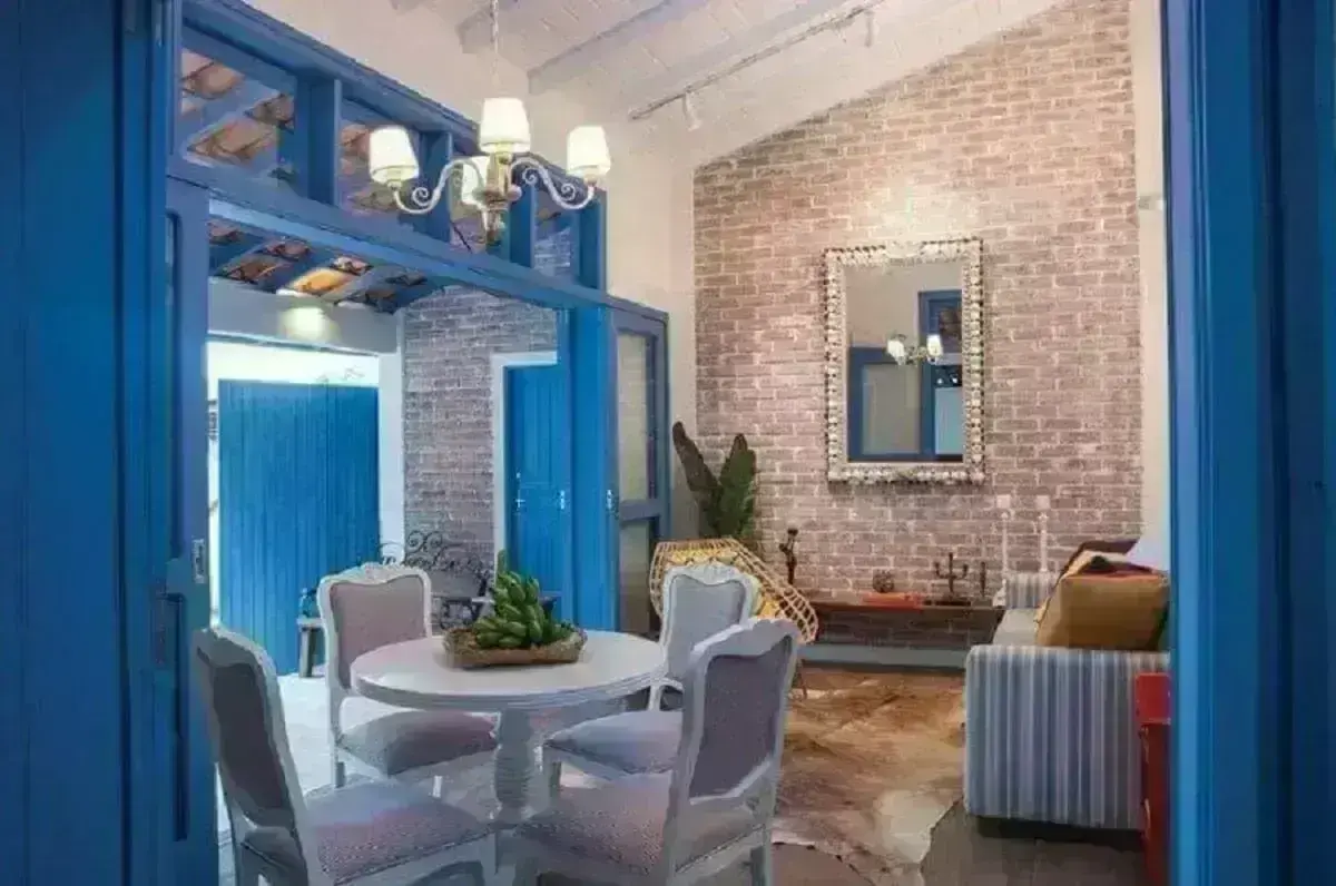 tons de azul para decoração clássica de sala com parede de tijolinho a vista