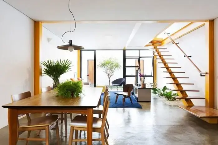 A escada flutuante de madeira se harmoniza perfeitamente com os móveis do local