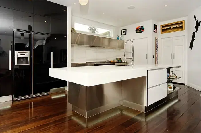 Cozinha ampla conta com a presença de uma geladeira preta duas portas