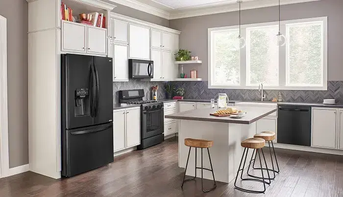 Cozinha clássica mesclando o branco dos armários com o preto dos eletrodomésticos