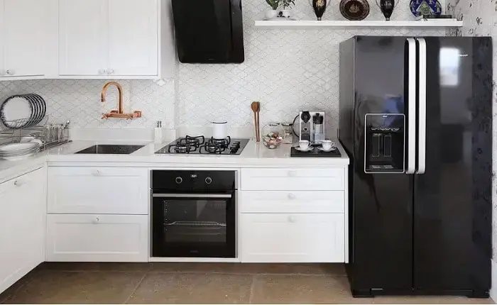 Cozinha com decoração clean e geladeira preta duas portas