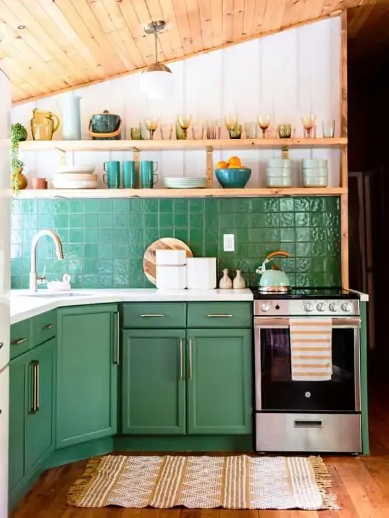 Cozinha com revestimento verde e armários