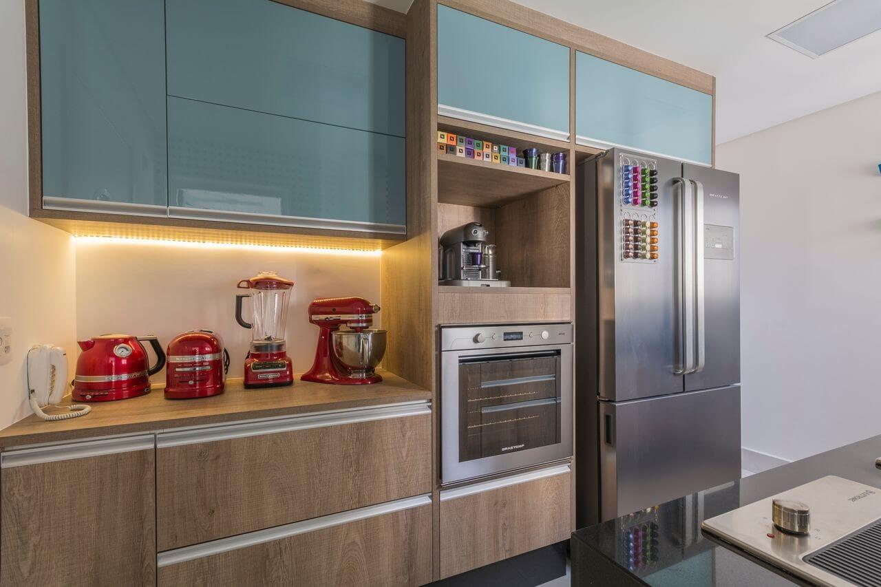 Cozinha modulada com armários em madeira e azul