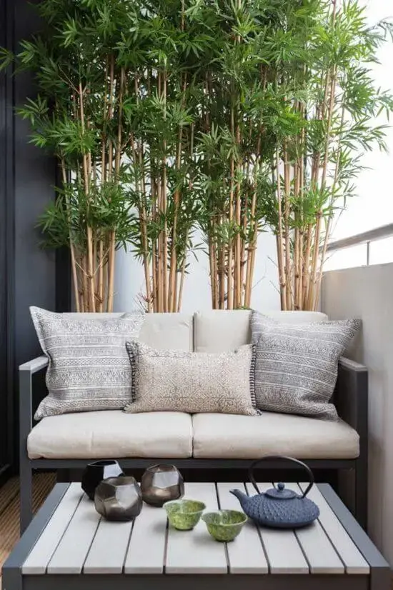 Decore a varanda com elementos em bambu, vasos de plantas e uma confortável namoradeira. Fonte: Pinterest