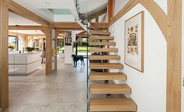 Escada flutuante de madeira complementa a decoração com estilo rústico dessa casa
