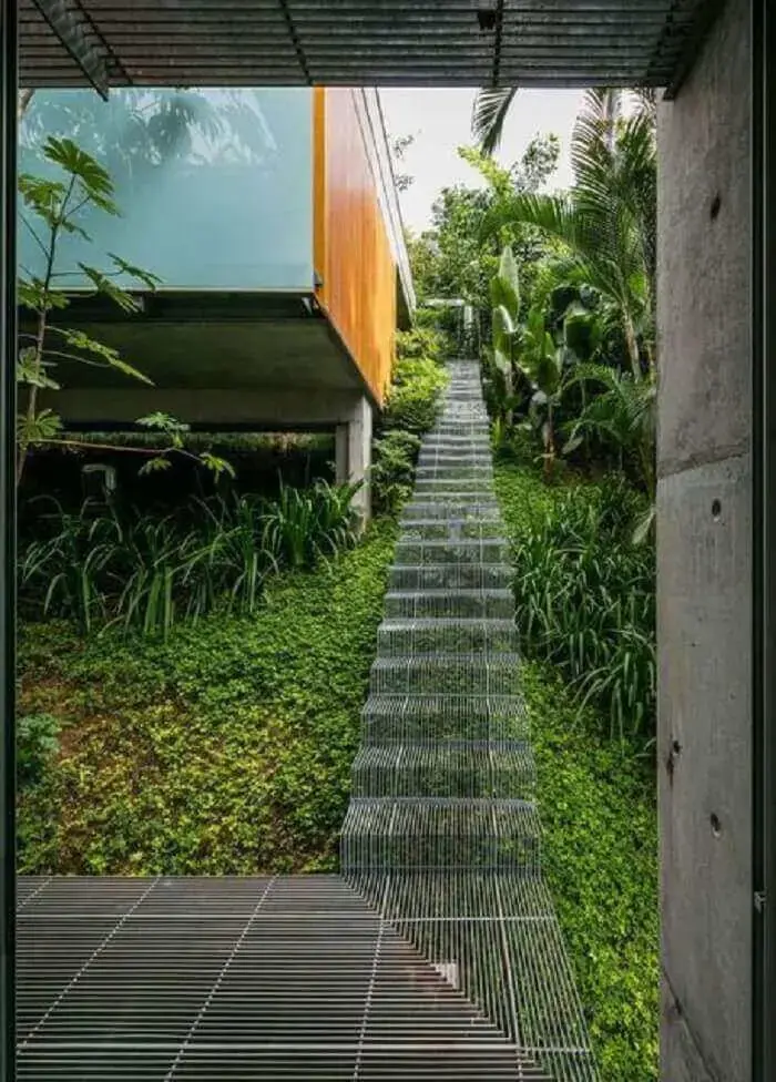 Escada flutuante utilizada em área externa da casa e sob a vegetação