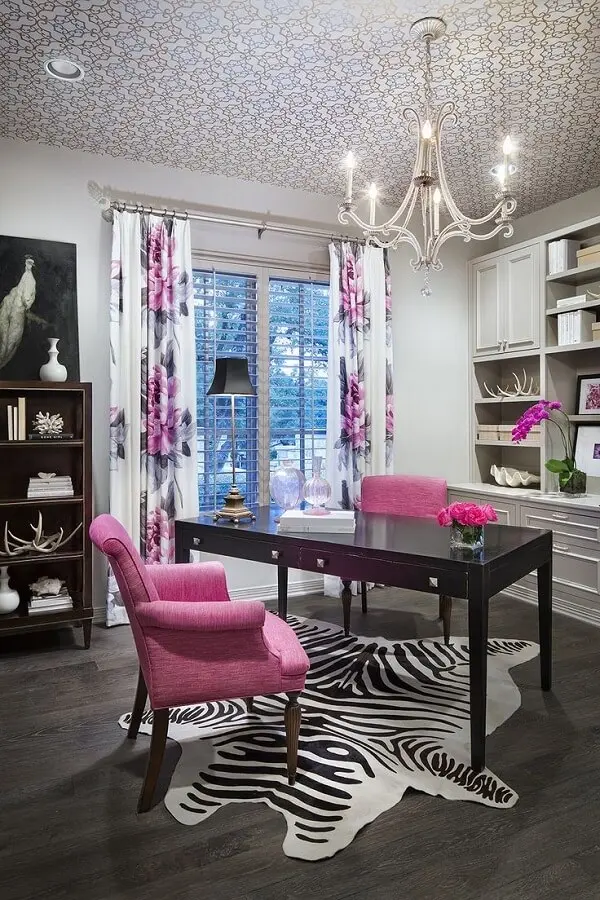 Escrivaninha preta e poltronas na cor rosa encantam a decoração desse ambiente