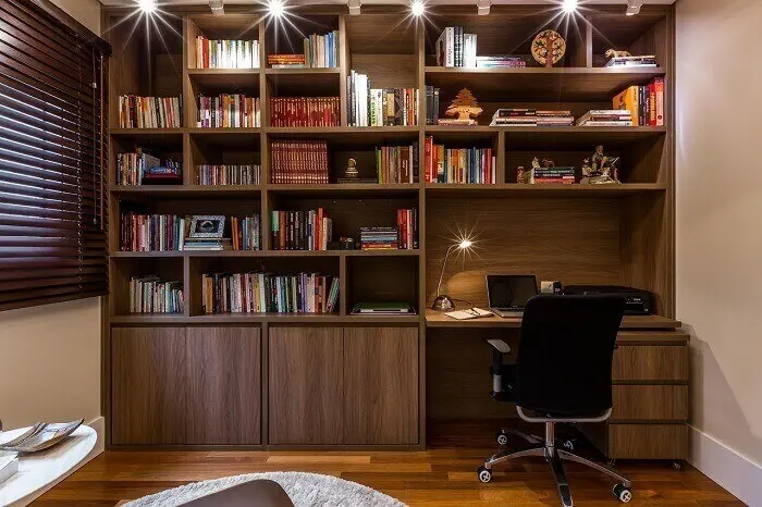 Home office e biblioteca integrados contam com a presença de uma cadeira para escritório presidente