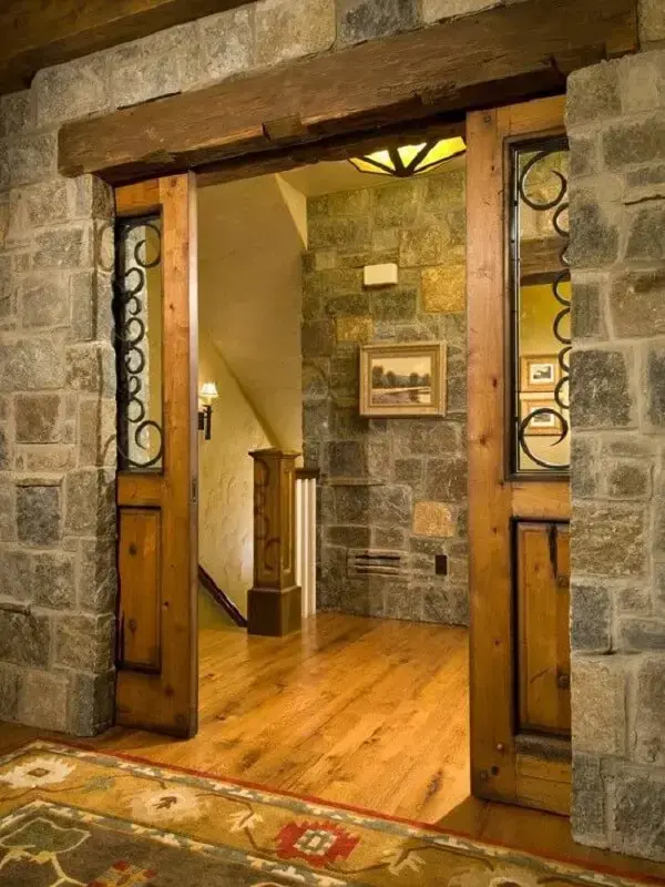 Parede de pedra e porta balcão de madeira. Fonte: Pinterest