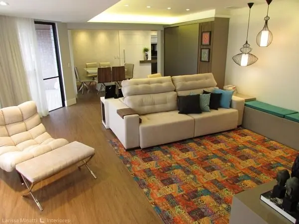 Sofá claro, tapete colorido e teto de gesso encantam a decoração da sala de estar