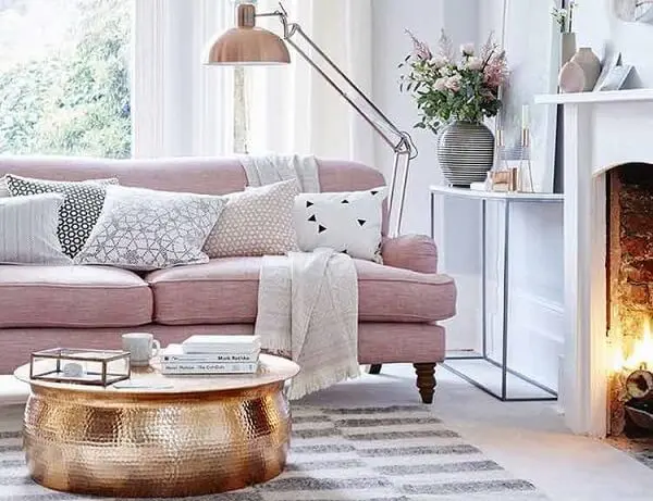 Sofá rosa e mesa de centro dourado encanta a decoração desta sala de estar