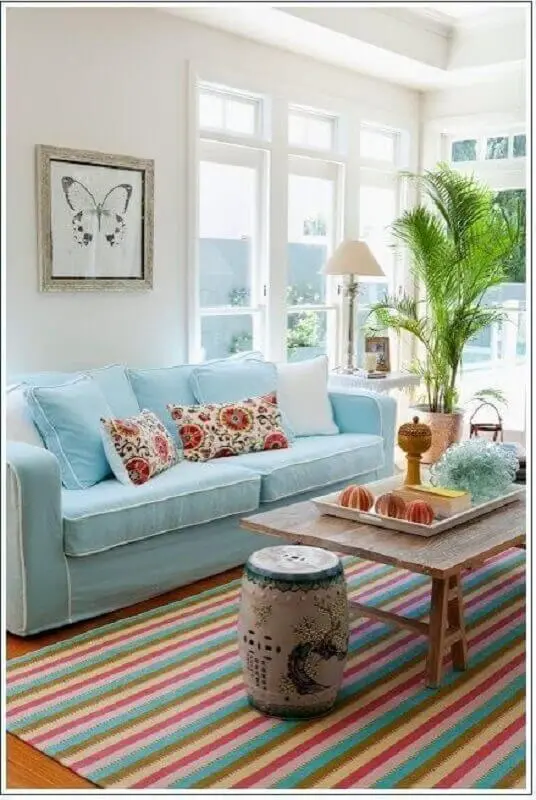 decoração clean para sala com sofá azul claro e tapete colorido listrado Foto Pinterest