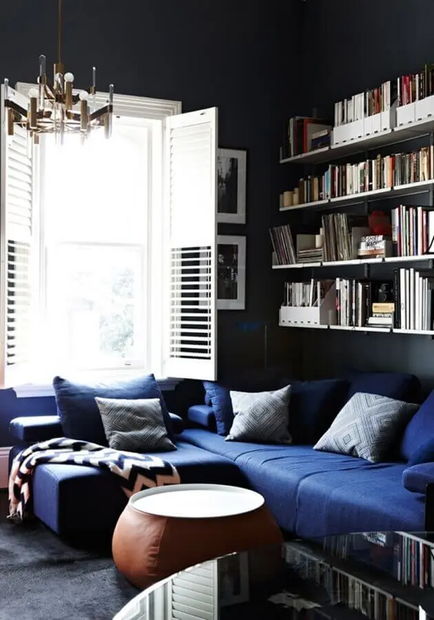 decoração com sofá azul escuro e prateleiras para livros Foto Yandex