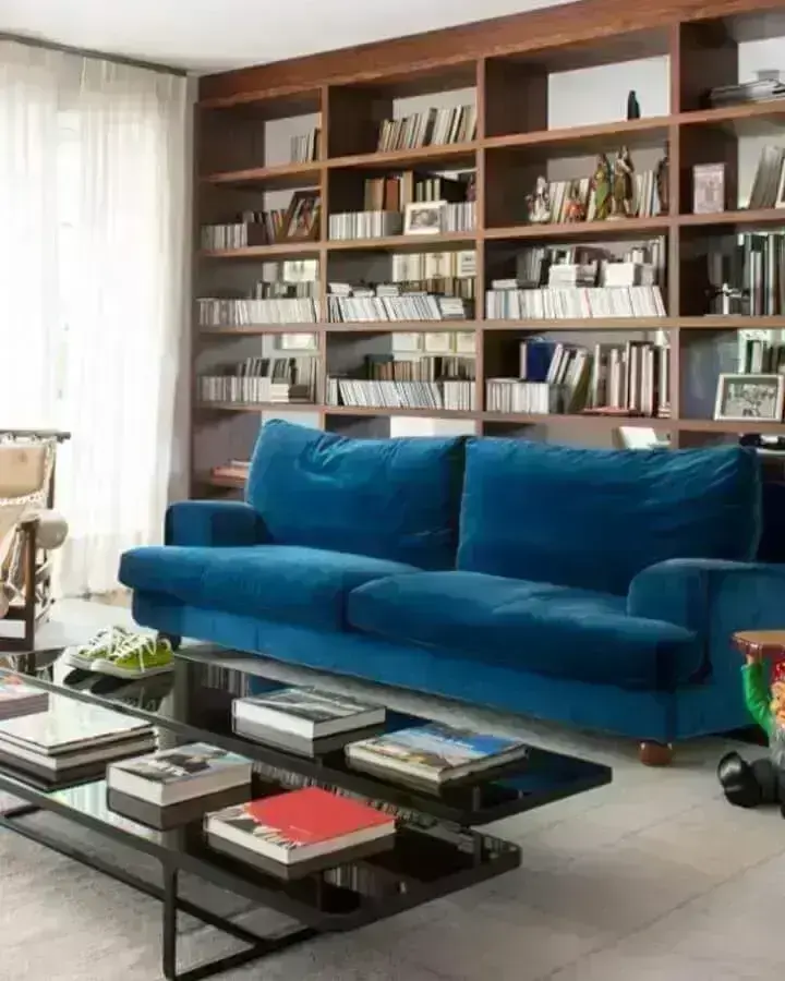 decoração de sala com estante de madeira para livros e sofá azul petróleo Foto Antonio Ferreira Junior