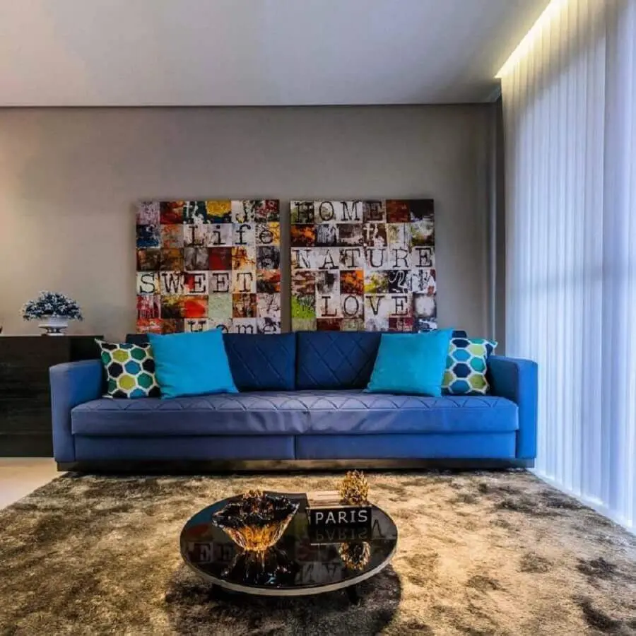 decoração para sala com sofá azul e quadros coloridos Foto Lo Interiores