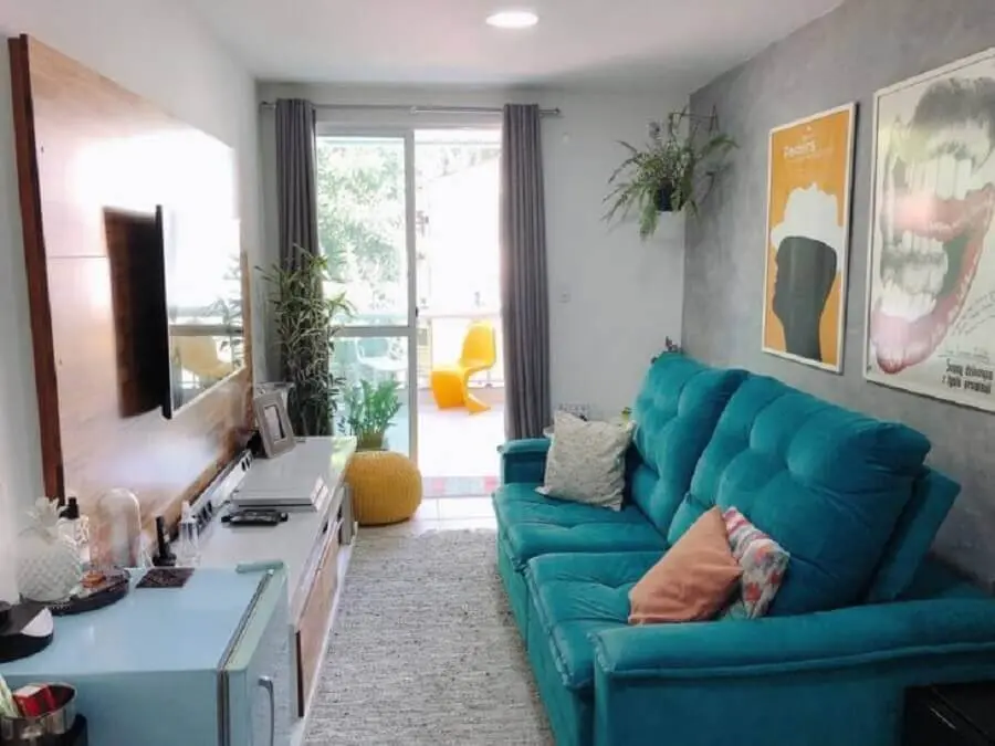 decoração para sala pequena com painel de madeira e sofá azul Foto Apê Pieno di Vita