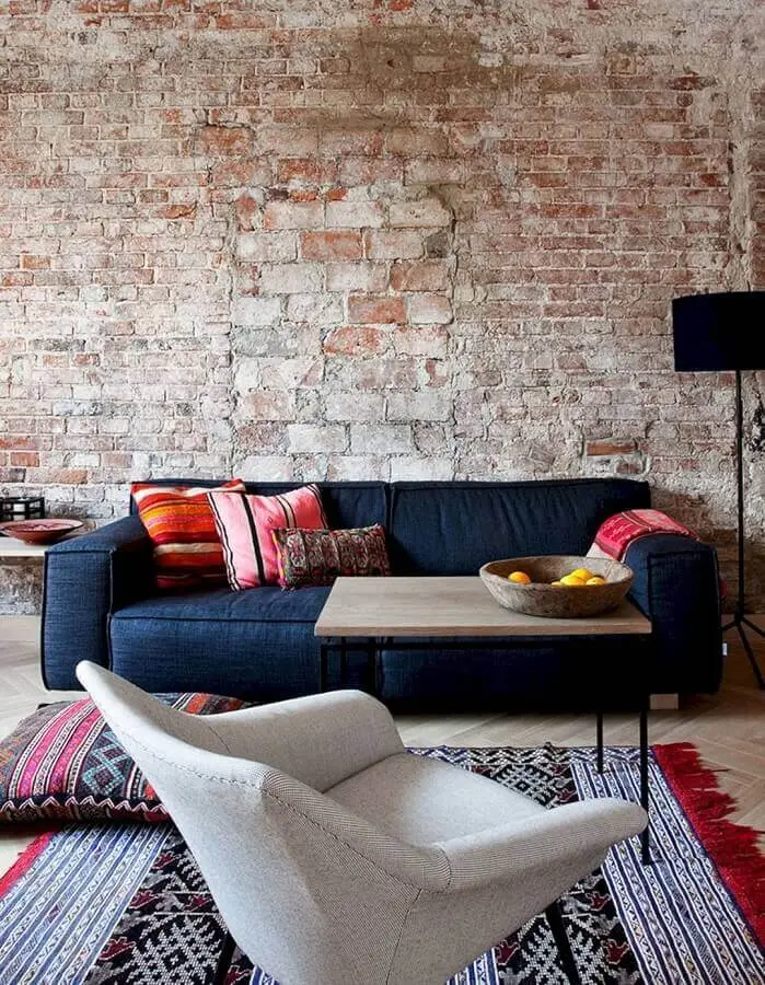 decoração rústica para sala com parede de tijolinho e sofá azul escuro Foto yandex