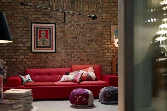 Parede de tijolinho aparente e sofá vermelho