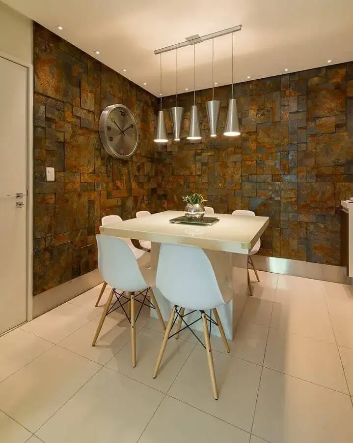 revestimento pedra ferro para sala de jantar com mesa pequena e luminárias modernas Foto Homify