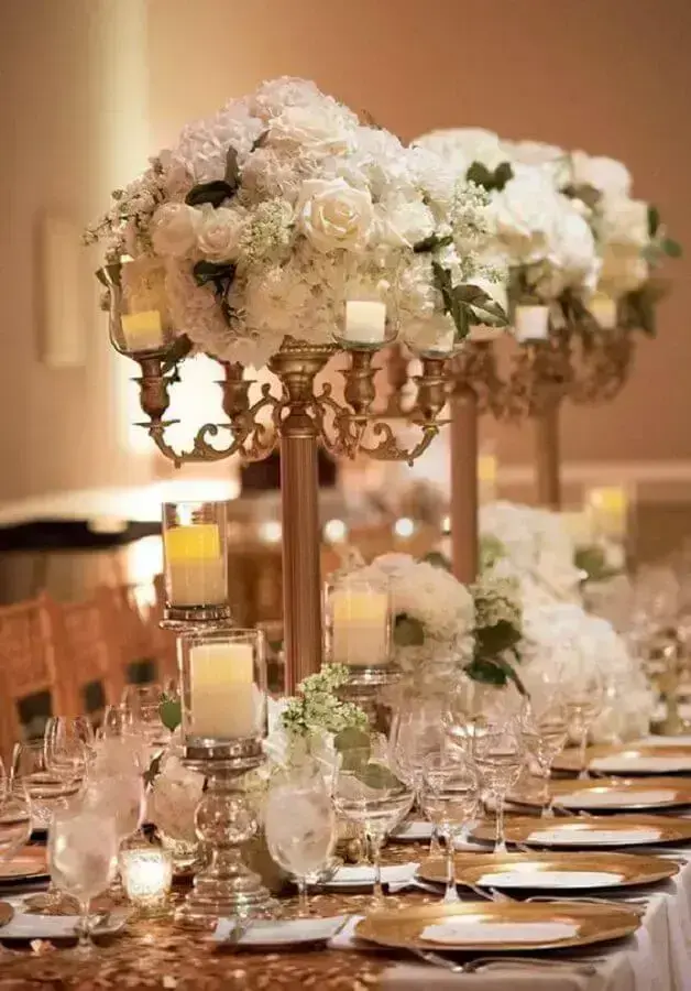 sofisticados enfeites para mesa de casamento com rosas brancas e castiçais dourados Foto Pinterest