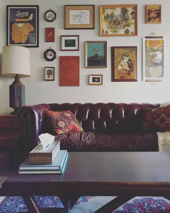 sofá chesterfield - sala de estar com sofá chesterfield de couro e quadros decorativos 